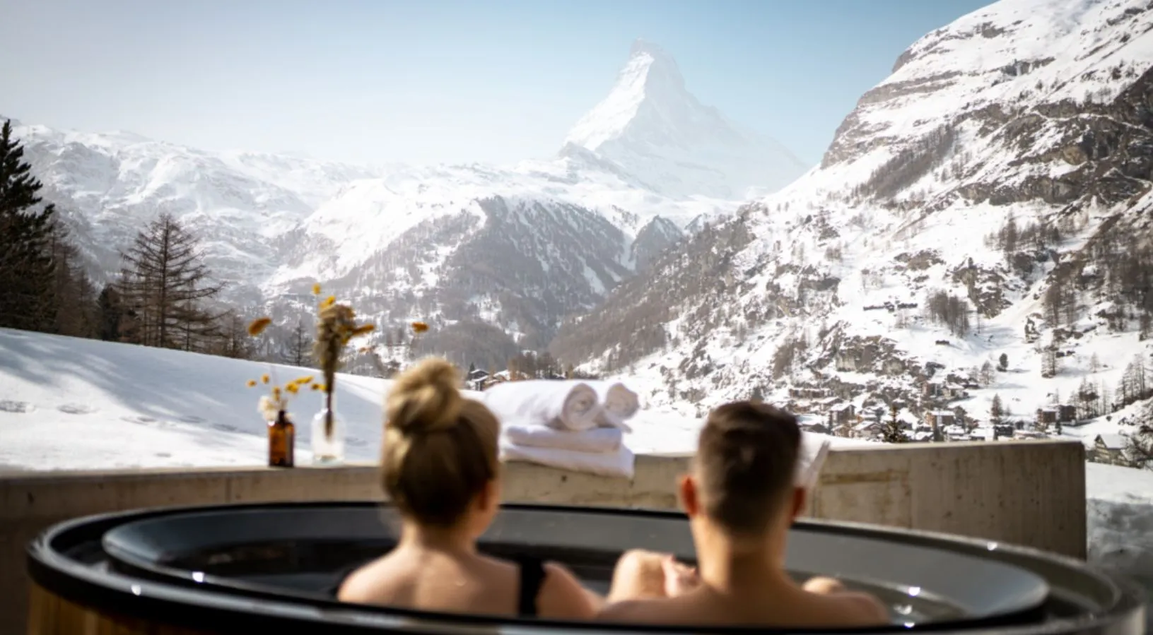 Couple enjoying a hot bath looking at the Mountains of Switzerland