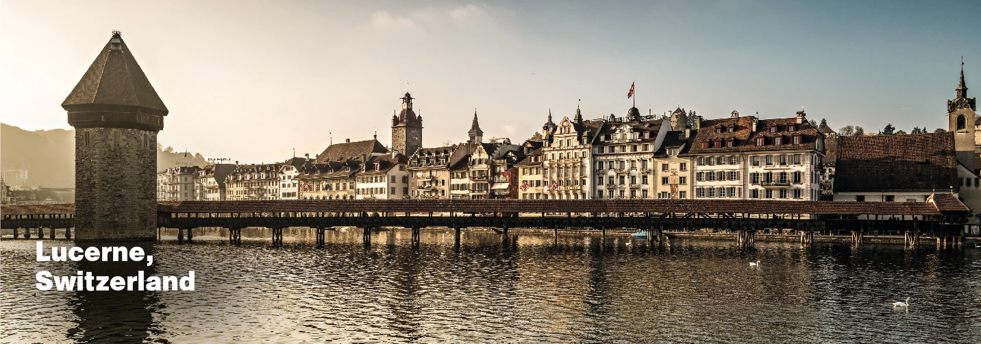 Evening view of Lucerne's old town and Chapel Bridge reflecting on the lake, a classic highlight of a romantic Switzerland Tour Package for couple.