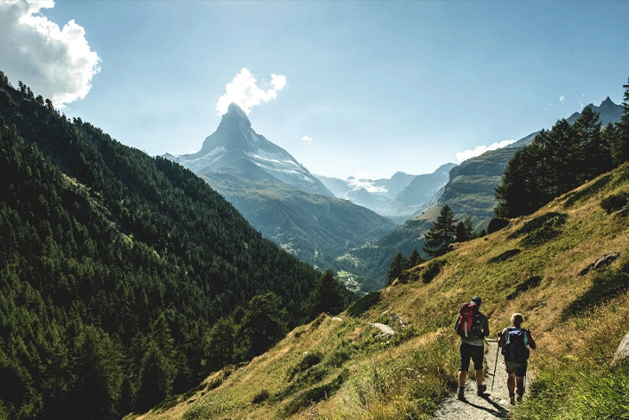 A group of people hiking on a trail in Zermatt, Switzerland.