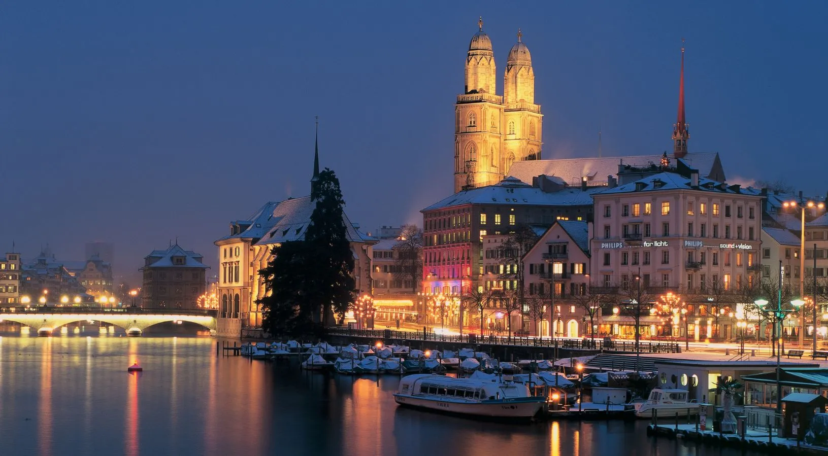 Zurich city skyline at night along the Limmat River featured in many Switzerland Tour Packages