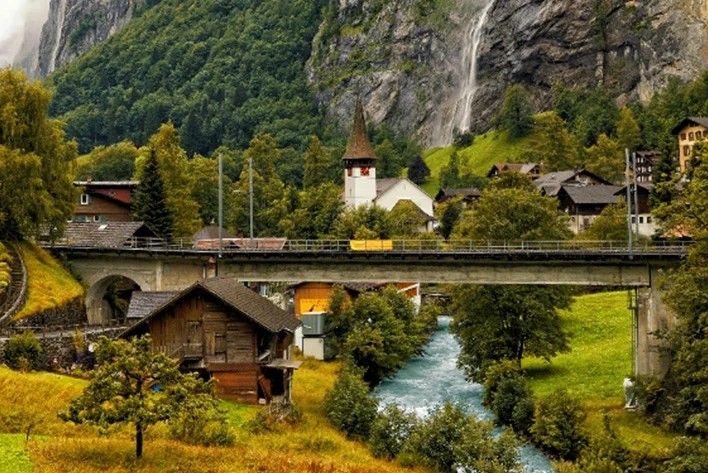 Majestic Staubbach Waterfalls From A Rocky Mountain